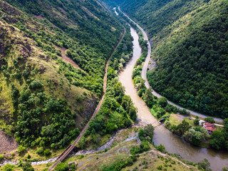 Aerial view of river through forest and mountains, cloudy sky. Ibar river in Serbia