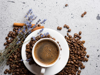 Close-up of white espresso coffee Cup , scattered roasted coffee beans and cinnamon