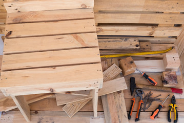 View of the table of carpenter. A lot of tools and wood and a chair on progress. Hobby and work outdoor in the terrace