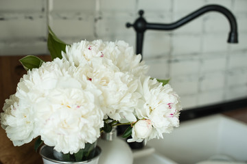 white peonies in the interior. kitchen with white flowers