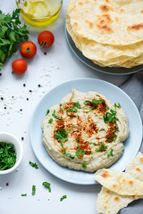 Eggplant dip baba ganoush (mutabbal) with herbs and paprika on gray wooden background. Selective focus. Traditional arabian food. Top view