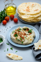 Eggplant dip baba ganoush (mutabbal) with herbs and paprika on gray wooden background. Selective focus. Traditional arabian food