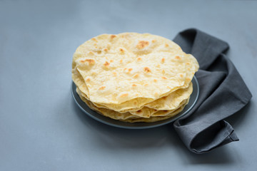 Stack of pita, Arabic bread, flatbread on gray wooden background. Soft focus. Traditional arabian...