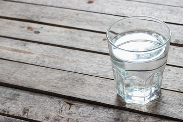 Fresh water in the glass on wooden table.