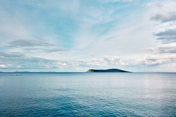 Beautiful minimalist nature background of an island and blue sea at sunrise. Freedom, refreshment,...