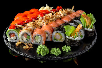Sushi set with fresh ingredients on black background. Sushi menu. Japanese food. 