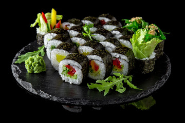 Sushi set with fresh ingredients on black background. Sushi menu. Japanese food. 