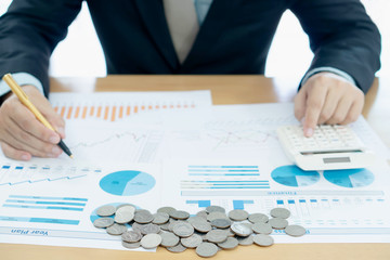 Businessman hand using calculator and reports document financial counting making