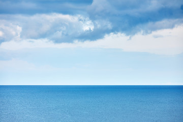 Minimalist aerial nature landscape background with calm sea and rain clouds over the sea in the morning at winter time.