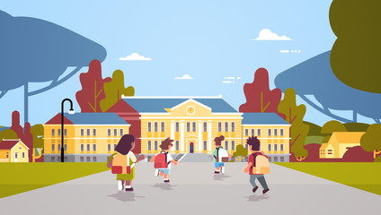 rear view children group with backpacks running back to school education concept mix race pupils in front of building landscape background flat full length horizontal