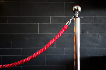 Single silver stanless stanchion with red velvet rope. Crowd control concept. Barrier rope isolated...