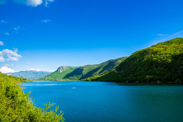 Montenegro, Barrier lake water of jezero liverovoci in a green valley surrounded by trees and forest near niksic city in beautiful nature landscape with blue sky