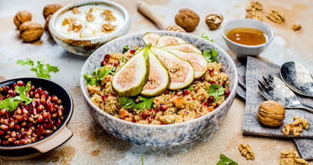 close-up view of tasty healthy couscous salat with figs fruits, nuts and pomegranate seeds 