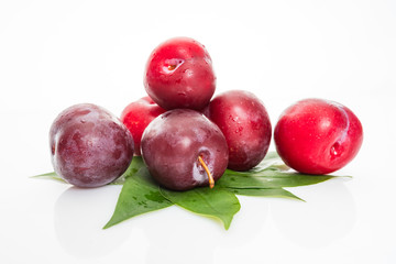 plums with plum leaves isolated on a white background