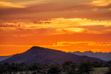 A sunset over a distant mountain in the Sonoran Desert of Arizona