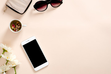 Flatlay composition with feminine accessories, tea cup, smartphone blank screen mockup, sunglasses,...