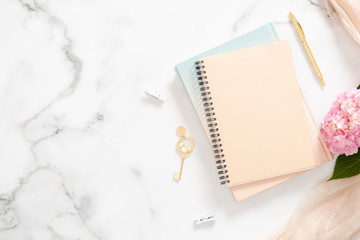 Modern home office desk workplace with blank paper notebook, pink hydrangea flower, pastel blanket...