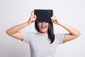 Young Asian woman with a computer tablet over her face.