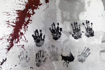 Light wall with prints of children's hands and drips of red paint