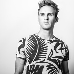 Elegant young handsome man in stylish T-shirt. Black-white photo.