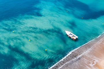 Aerial view of a boat on water and sandy coastline view