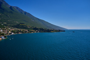 Naklejka na ściany i meble Aerial photography with drone, on the medieval lakeside castle with a museum of history and paleontology, as well as a panoramic view from the tower. City of Malcesine on Lake Garda, Italy.