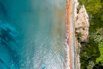 Aerial view of sandy coastline with crystal sea water