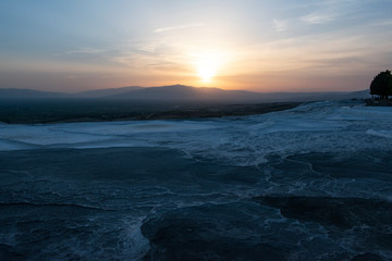 Turkey, sunset on the travertine terraces at Pamukkale (Cotton Castle), natural site of sedimentary rock deposited by water from the hot springs, famous for a carbonate mineral left by flowing water