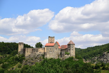 Fototapeta na wymiar Hardegg medieval castle on a fortified hill in Thayatal National Park on sunny day with cloudy blue sky.