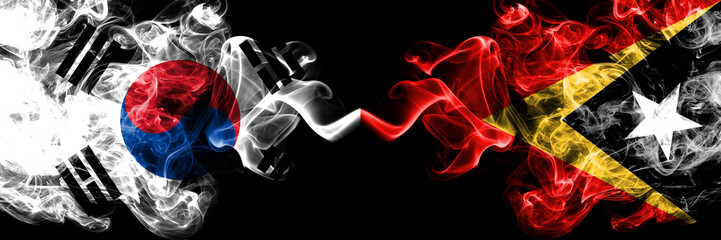 South Korea vs East Timor smoky mystic flags placed side by side. Thick colored silky abstract smoke flags of South Korean and East Timor