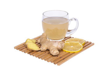 Ginger root tea in glass mug, lemon slices on a bamboo coaster.