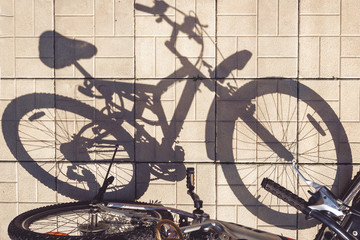 Fototapeta na wymiar Bike shadow on asphalt day light, creative flat lay top view