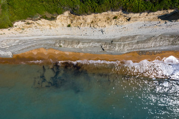 Aerial view of beautiflul rocky cliff and sandy beach by the ocean.