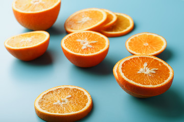 Round slices of juicy orange on a blue background, top view as a background substrate. Food background