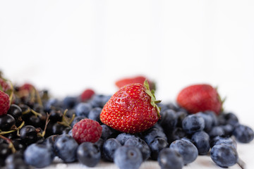 ripe berries strawberries, blueberries, raspberries and currants on a white table. Delicious summer berries