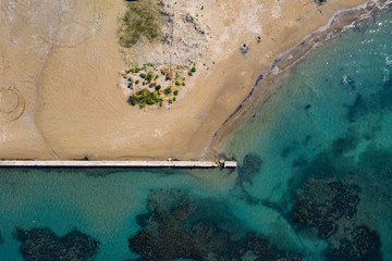 Aerial view of sandy coastline with crystal sea water