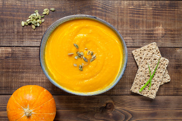 Pumpkin soup on wood background. Top view