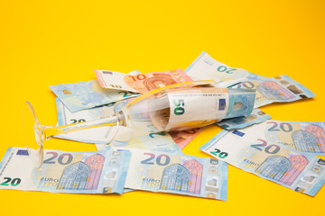 Copa de champagne, llena de billetes de dinero de curso legal. Copa de cristal llena de dinero y dinero encima de una superficie.