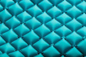 Texture of a blue inflatable tourist rug, repeating sections and patterns. Air mattress Ultralight Portable rug.