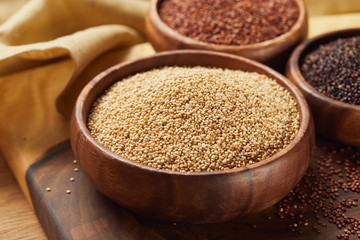 selective focus of white quinoa in wooden bowl