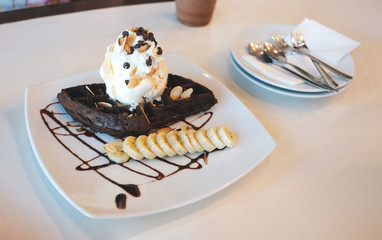 Dark waffle with ice-cream white vanilla and beans topping on top decorated with banana in coffee shop from high angle view