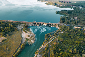 Aerial panoramic view of concrete Dam at reservoir with flowing water, hydroelectricity power station, drone shot