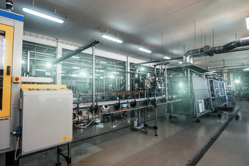 Modern beverage factory or plant interior with special industrial food production equipment. Automated conveyor belt