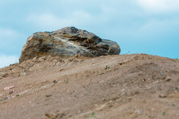 Sand embankment with a large rock on the top