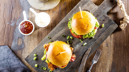 gourmet hamburgers, french fries and glasses of beer on table  
