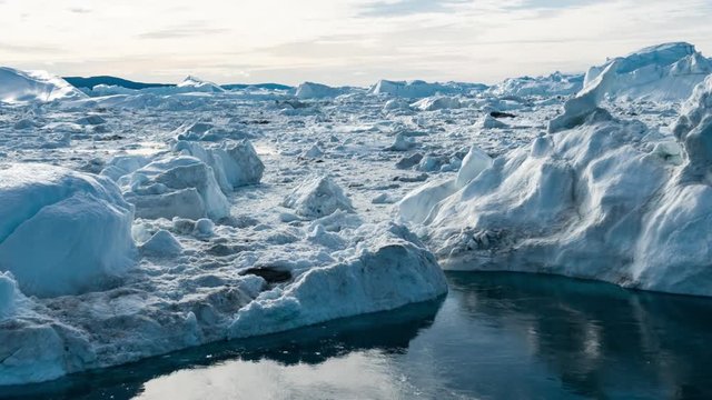 Iceberg aerial drone video- giant icebergs in Disko Bay on greenland floating in Ilulissat icefjord from melting glacier Sermeq Kujalleq Glacier Affected by Global warming and climate change.