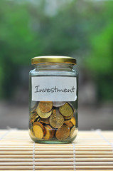 Coins in bottle with label Investment - financial concept