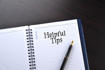 Notebook with fountain pen on wooden table with word Helpful Tips