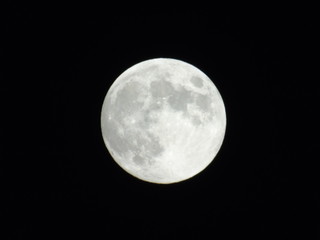 An amazing photography of the full moon over the city of Genova by night with a great clear sky in background and some stars