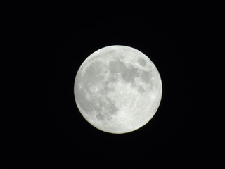 An amazing photography of the full moon over the city of Genova by night with a great clear sky in background and some stars